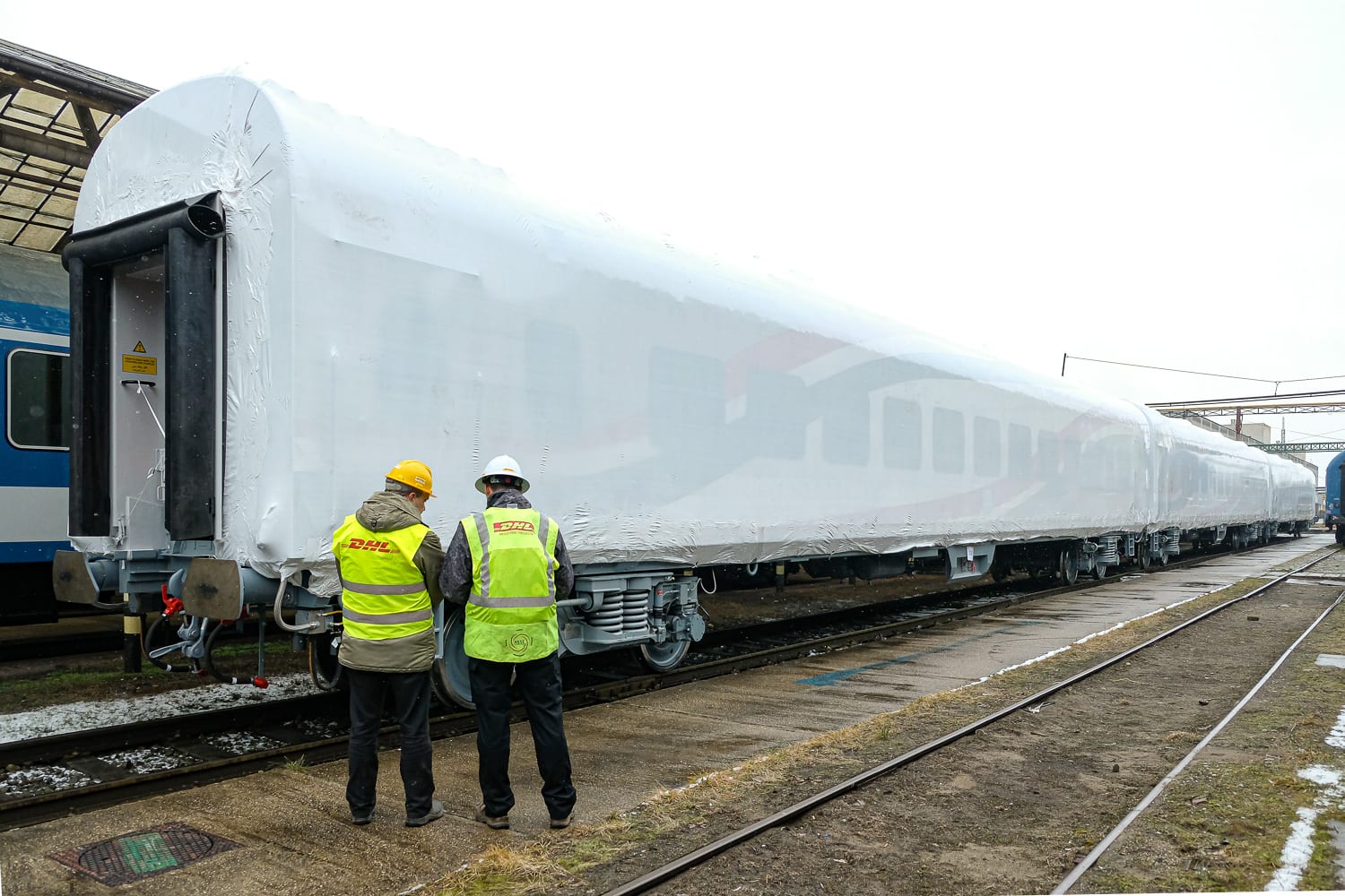 Two members of the DHL Industrial Projects team preparing the rail coaches for shipment