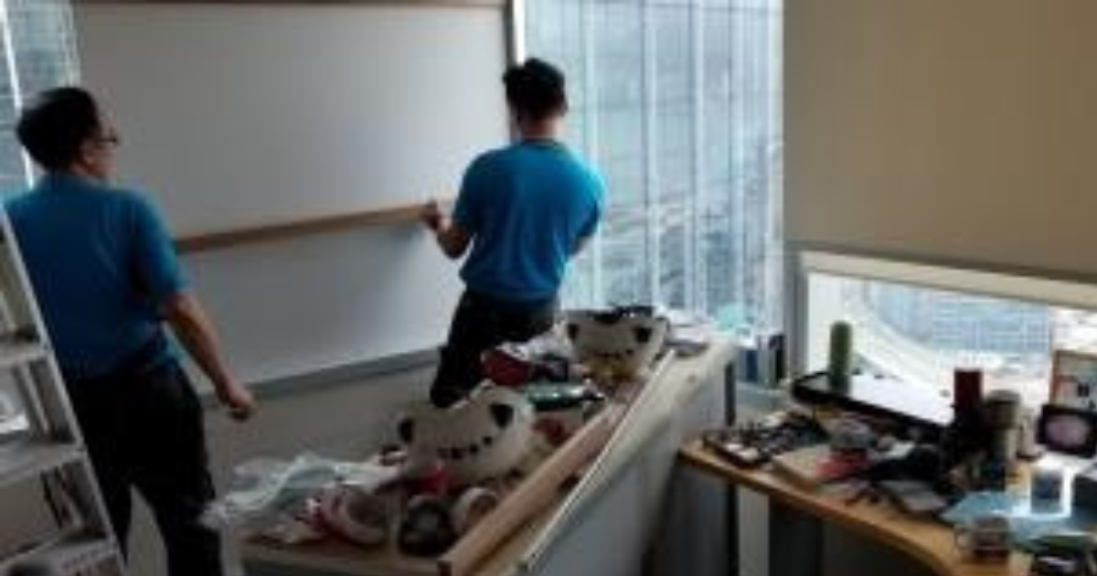 Employees in Hong Kong use temporary wooden reinforcements to block a window that was broken during the typhoon.