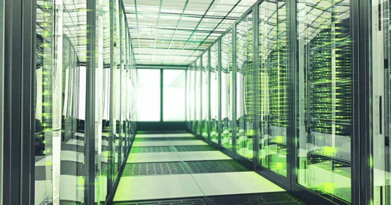 Shot of corridor inside server room of a data center, full of rack supercomputers mainframe.